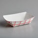 A white paper food tray with a red and white checkered pattern.