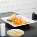 A plate of food with a tortilla wrap on a Milano white rectangular plate.