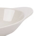 An ivory oval side dish with a curved edge.