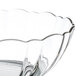 A close up of an Arcoroc clear glass bowl with a scalloped edge.