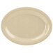 A beige oval platter with speckled edges on a white surface.