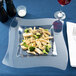 A Fineline clear plastic square plate with pasta and broccoli on it.