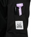 A close up of a Chef Revival unisex black chef coat's pocket with a pen and a purple pen.