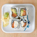 A Thunder Group Blue Bamboo rectangular melamine plate with a sushi roll with salmon and avocado.