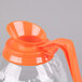 A Grindmaster glass coffee decanter with an orange plastic decaf handle.