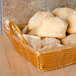 A basket of bread and rolls lined with Durable Packaging Green Choice kraft deli sheets.