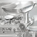 A Vollrath meat grinder attachment with metal container on a Vollrath mixer.