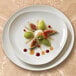 A Homer Laughlin Ameriwhite Alexa bright white triangle china plate with figs and cream on a table.