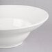 A Homer Laughlin white china bowl with a white rim on a gray surface.