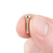 A person holding a small silver Waring screw.