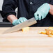 A chef in gloves cutting potatoes with a Mercer Culinary MX3 Japanese Gyuto knife.