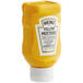 A yellow Heinz mustard squeeze bottle with a white label on white background.