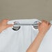 A person using chrome rings to hang a white Hookless shower curtain with a translucent window.