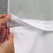 A person's hands using a Hookless white shower curtain with a zipper to attach the liner