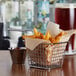 A metal basket lined with a Choice natural kraft deli wrap with French fries inside.