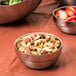 An American Metalcraft stainless steel bowl filled with nuts and strawberries.
