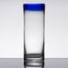 A clear Libbey zombie glass with a cobalt blue rim on a table.