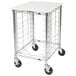 A white unassembled Metro wire sheet pan rack with black wheels.