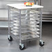 A Metro RE3P portable wire pan rack with trays on top in a school kitchen.