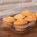 A Polar Pak clear plastic hinged container with muffins inside.