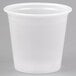 A close up of a Solo translucent plastic souffle cup on a white surface.