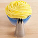 A cupcake with yellow frosting on top with an Ateco open star piping tip.