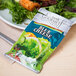 A Classic Gourmet Blue Cheese portion packet on a plate of salad.