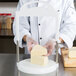 A chef uses a Matfer Bourgeat cheese slicer to cut cheese on a counter.