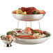 An American Metalcraft stainless steel two tiered seafood tray with crab legs and vegetables on a table.