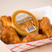 A basket of chicken wings with Classic Gourmet honey mustard dipping sauce.
