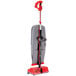 An Oreck upright bagged vacuum cleaner with a red handle and gray and red accents.