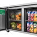A Turbo Air stainless steel undercounter refrigerator with fruit and juice in it.