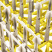 A white Vollrath Traex peg rack with yellow extended pegs.