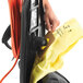 A person inserting a yellow bag into a Hoover Task Vac commercial bagged vacuum cleaner.