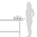 A woman standing next to a table with a Vollrath stainless steel food pan in it.