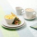 A Homer Laughlin ivory china plate with macaroni and cheese and salad on a table with coffee.