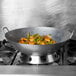 A Town hand hammered Cantonese wok on a stove filled with green beans and shrimp.