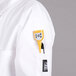 A person wearing a white Chef Revival chef coat with yellow tape on it.