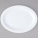 A white oval Carlisle Kingline melamine platter on a gray surface.