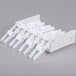 A white plastic rack with 7 removable white plastic rolls of Noble Products Day of the Week labels.