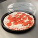A Solut black plastic container with a pizza, pepperoni, and cheese inside.