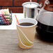An Eco-Products Evolution World paper hot cup filled with brown liquid and a straw.
