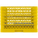 A yellow plastic Vollrath Traex plate rack with many rows of holes.