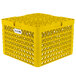 A yellow plastic Vollrath Traex plate rack with 12 compartments.