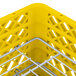 A yellow plastic basket with white metal grate holding plates.