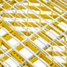 A close up of a yellow and white metal grid with white lines.