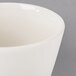 A close-up of a Homer Laughlin ivory china bouillon cup with a white rim.
