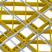 A yellow and grey plastic grid with metal bars.