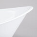 A close-up of a white Tablecraft melamine bowl with a curved edge.