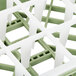 A close up of a green and white Vollrath plastic grid for a glass rack.